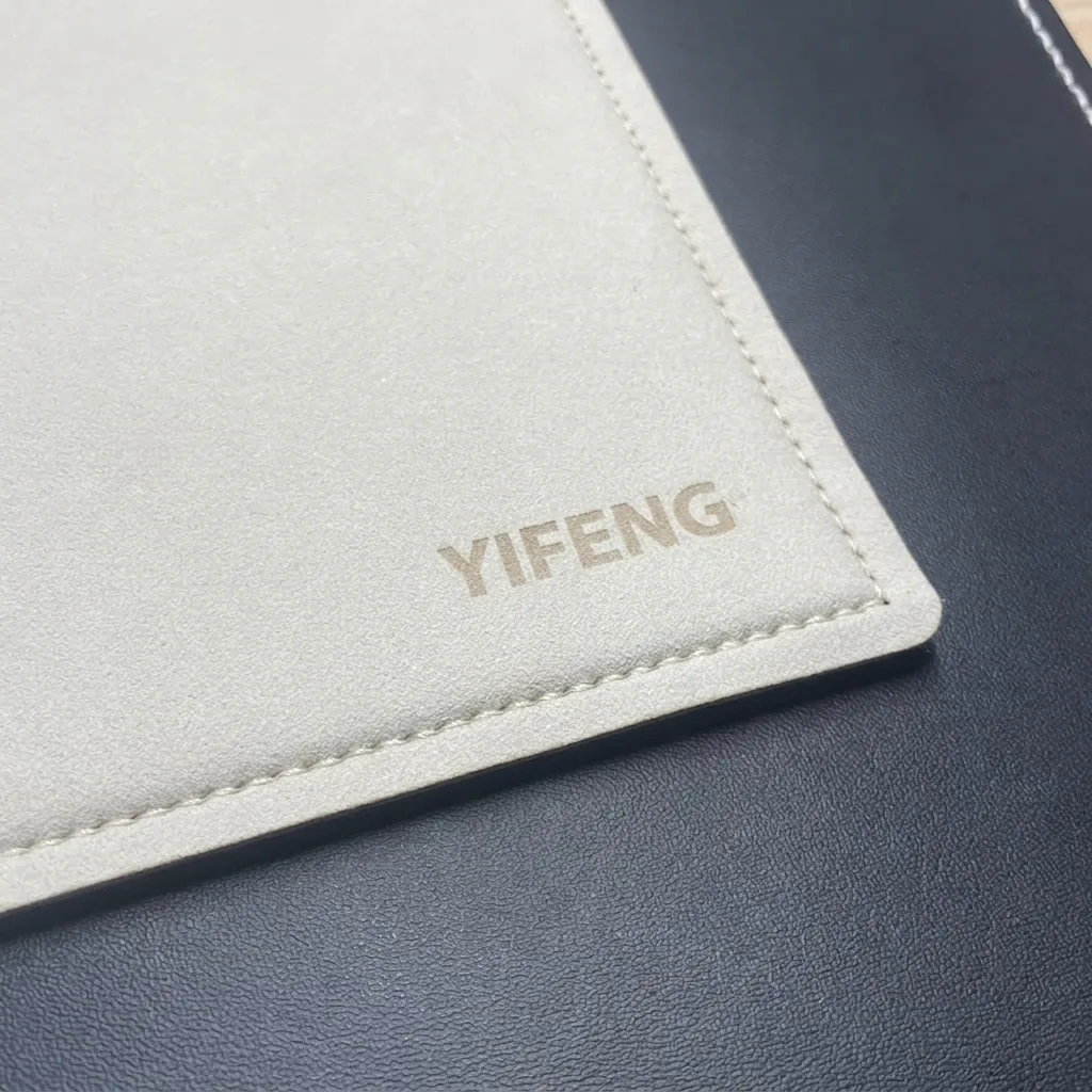 雷雕 YIFENG 字樣的米白色皮革桌墊